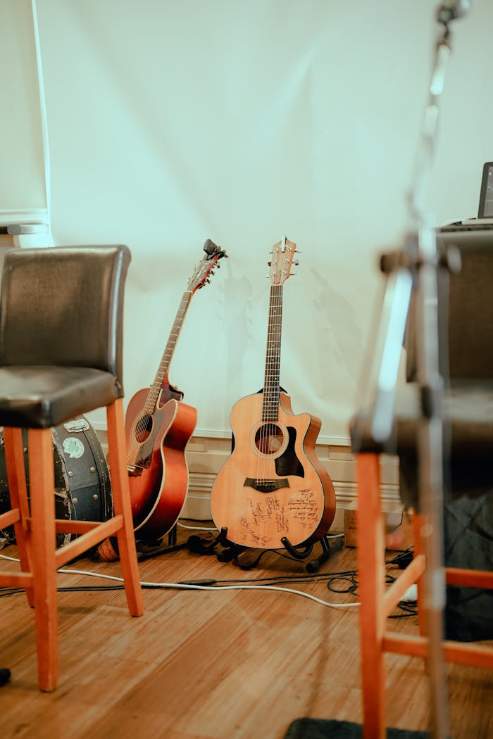 Crafting Captivating Headlines: Your awesome post title goes here Two acoustic guitars resting indoors, surrounded by chairs, with a warm and inviting ambiance.