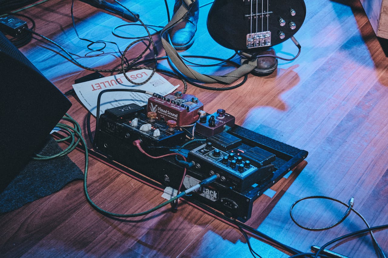 The Art of Drawing Readers In: Your attractive post title goes here Close-up of a guitar pedal board on stage floor with a bass guitar and cables.
